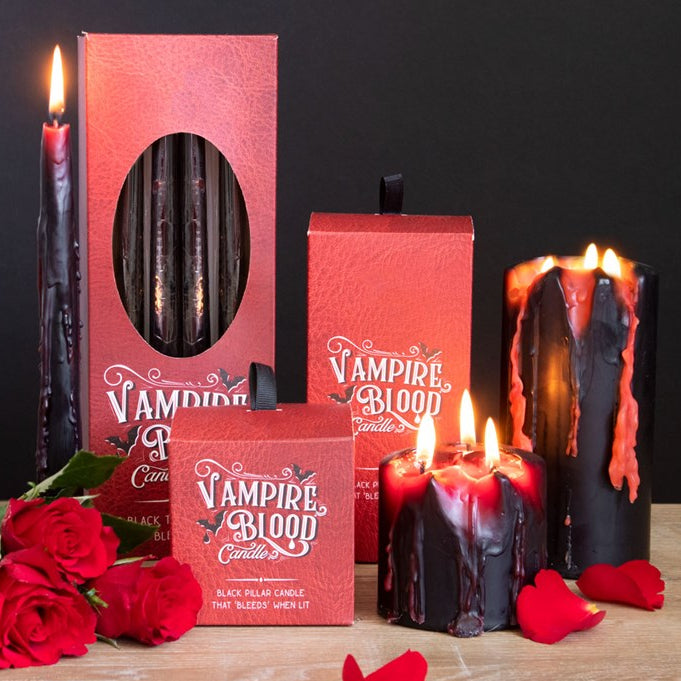 Vampire-themed candles with red and black colors, surrounded by roses on a dark background.