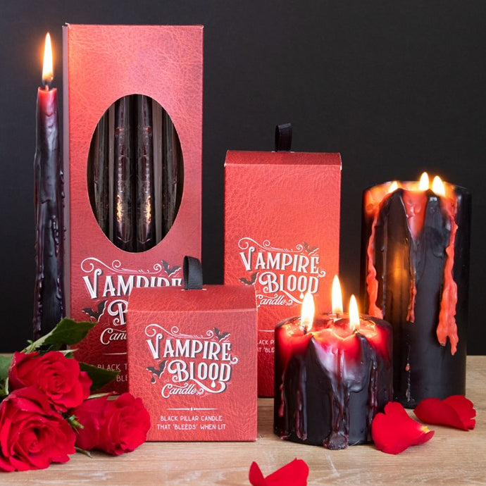 Vampire-themed candles with red and black colors, surrounded by roses on a dark background.