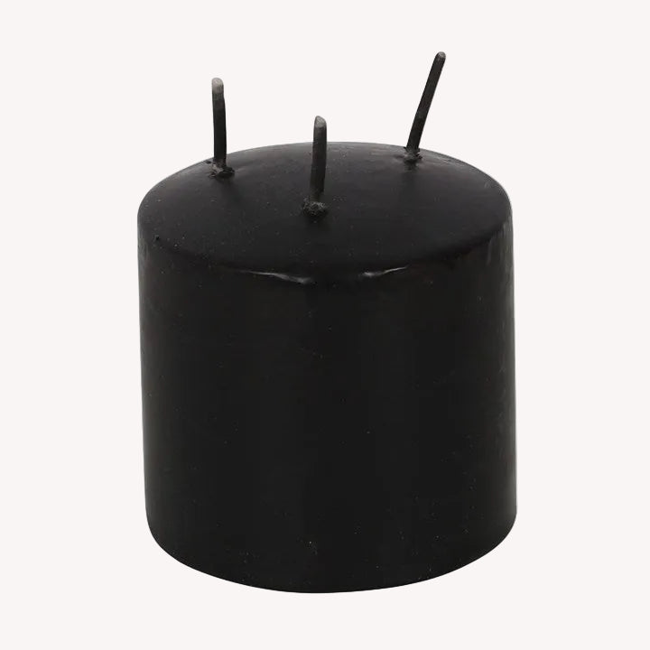 Black cylindrical candle with three wicks on a white background