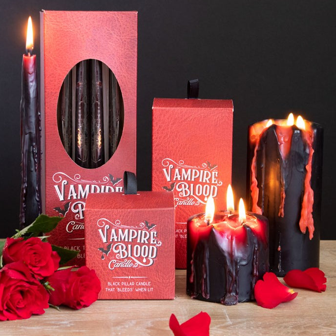 Vampire-themed candles with red and black colors, surrounded by roses on a dark background.
