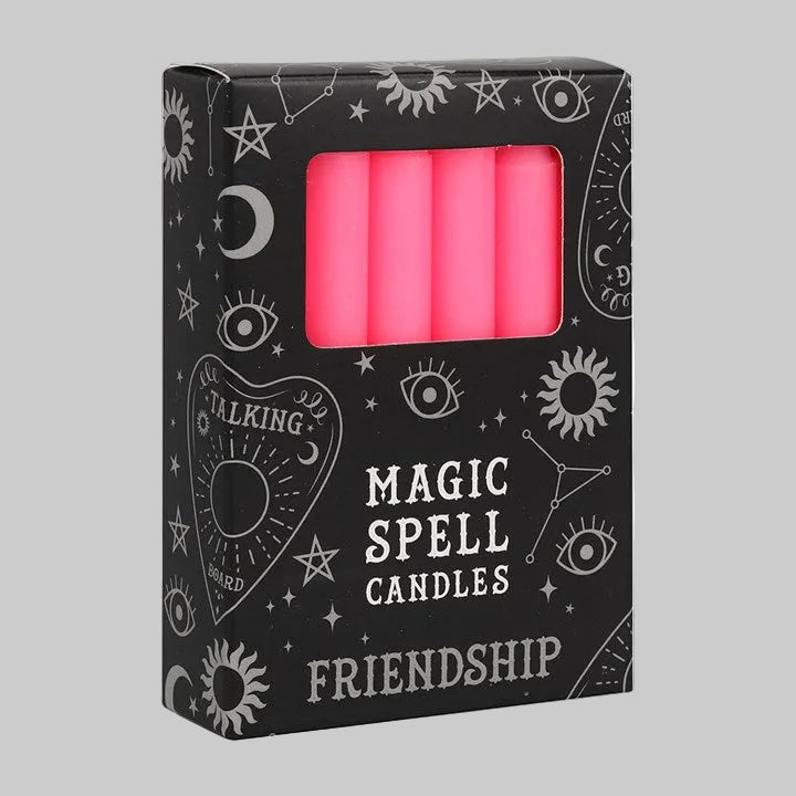 Box of pink 'Magic Spell Candles' with 'Friendship' text on a black background with white designs.