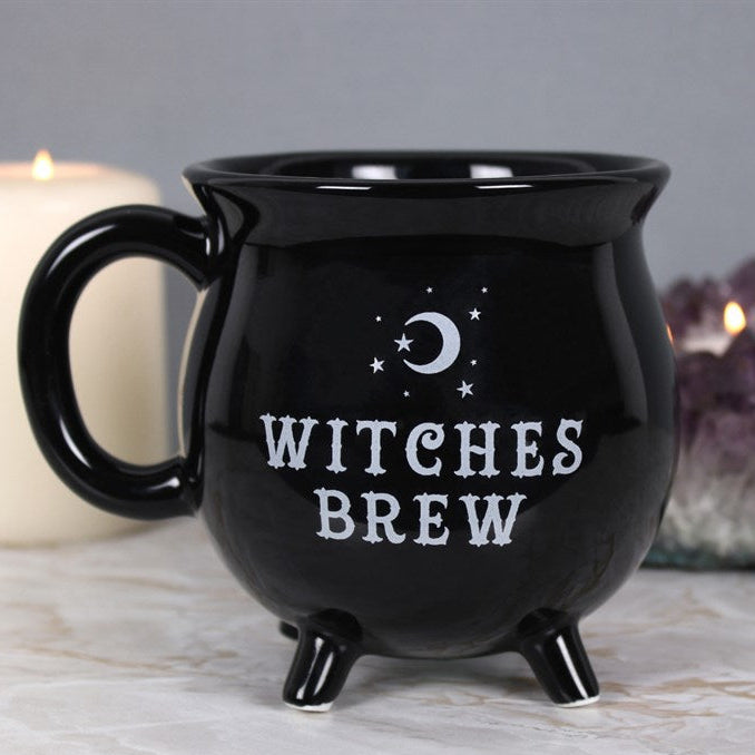 Black mug with 'Witches Brew' text and moon and star design on a neutral background