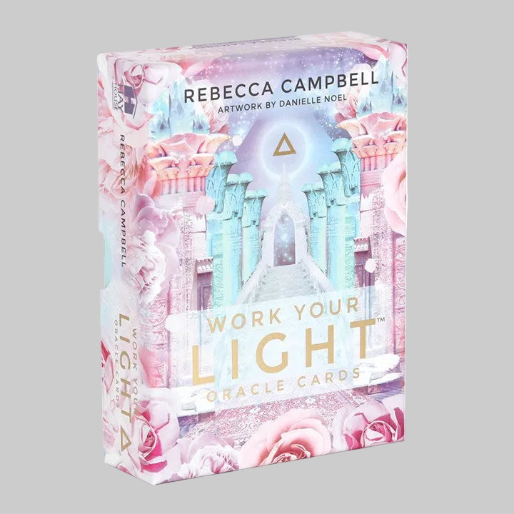 Box of 'Work Your Light' oracle cards with pastel designs and text.