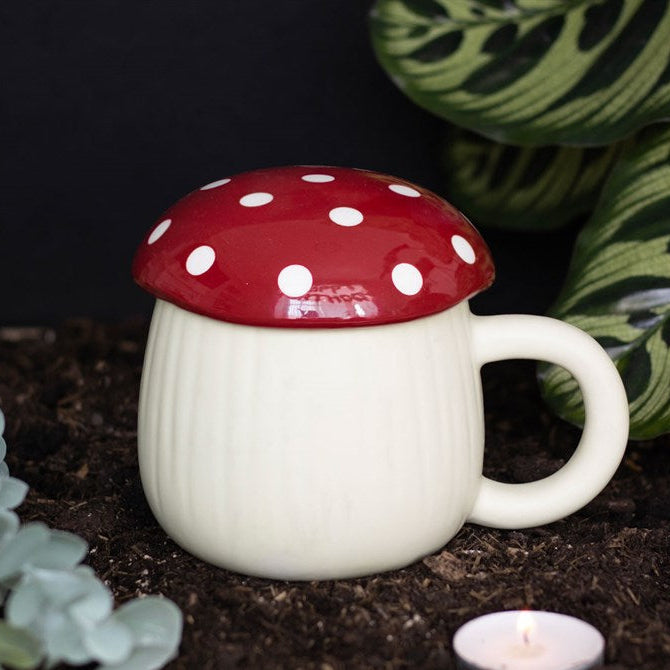 Mushroom-shaped mug with a red cap and white spots on a dark background