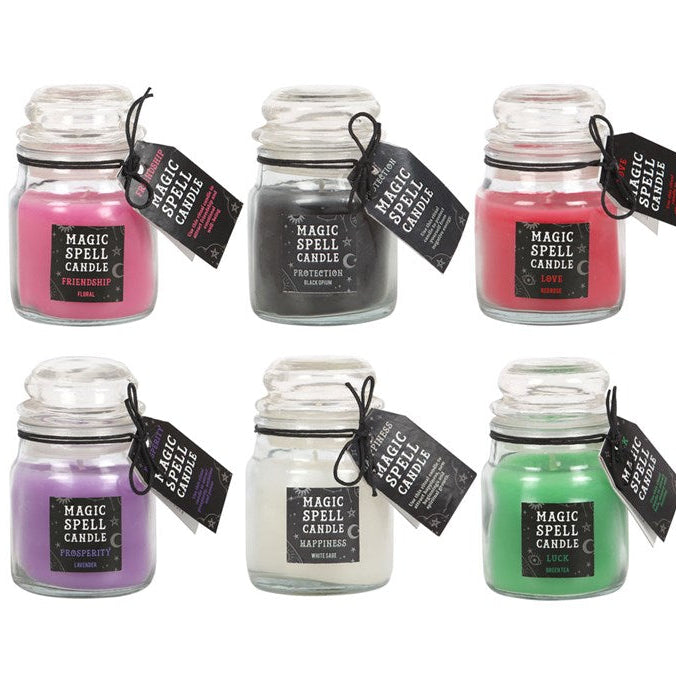 Set of six small glass jars with colorful candles and labels on a white background