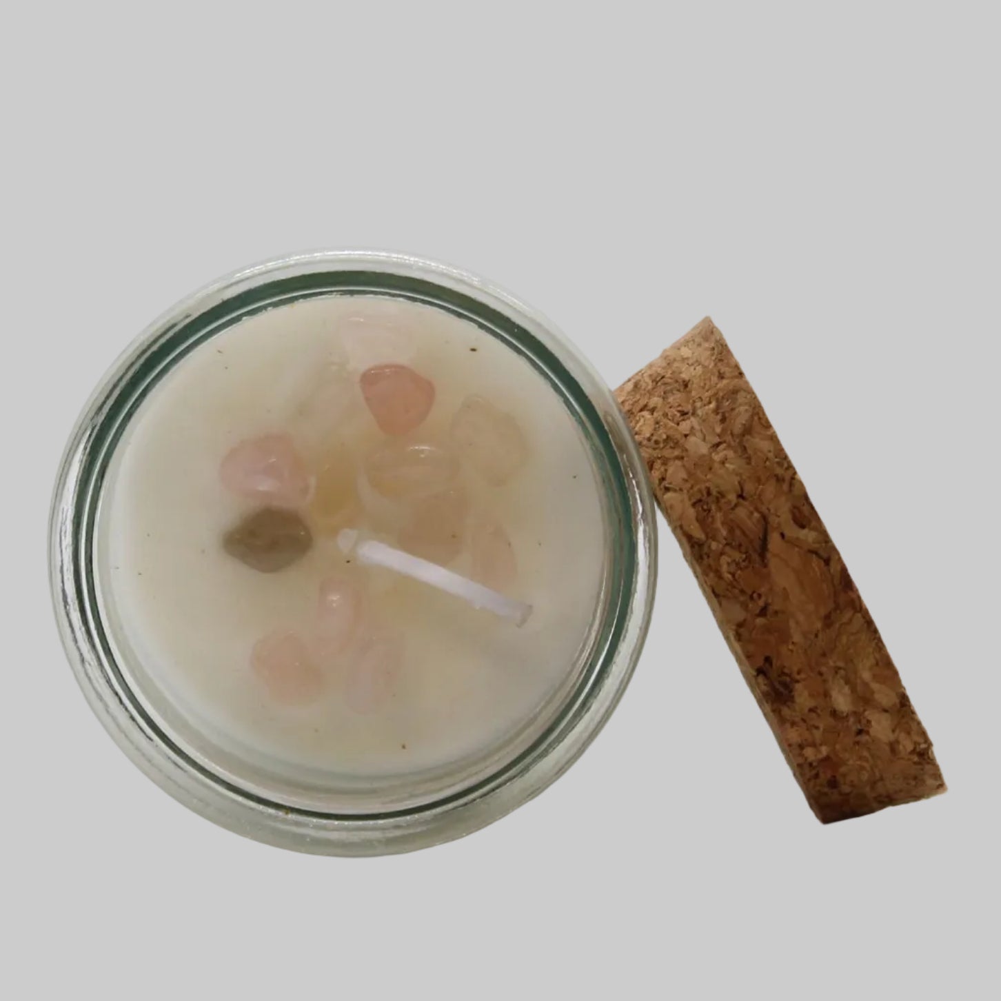 Candle in a glass jar with a cork lid on a white background