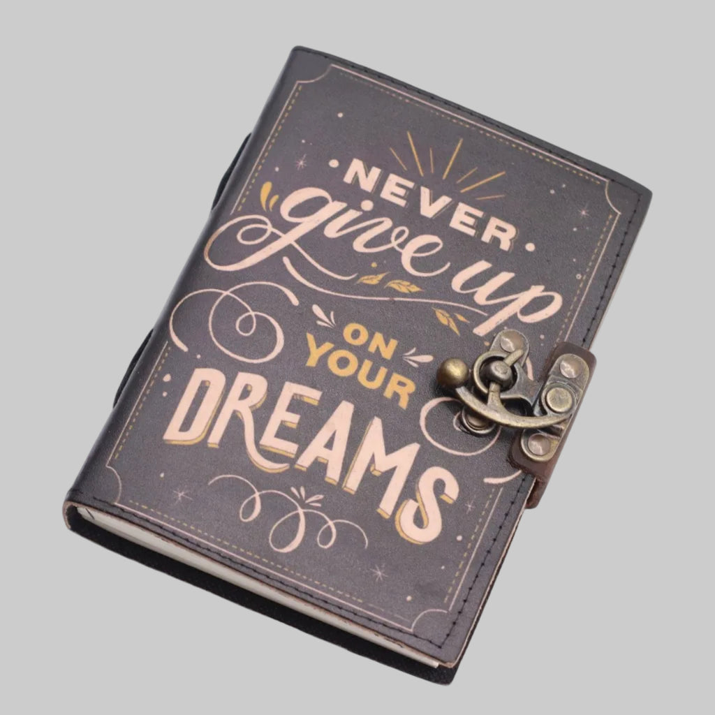 Journal with 'Never give up on your dreams' text on a white background