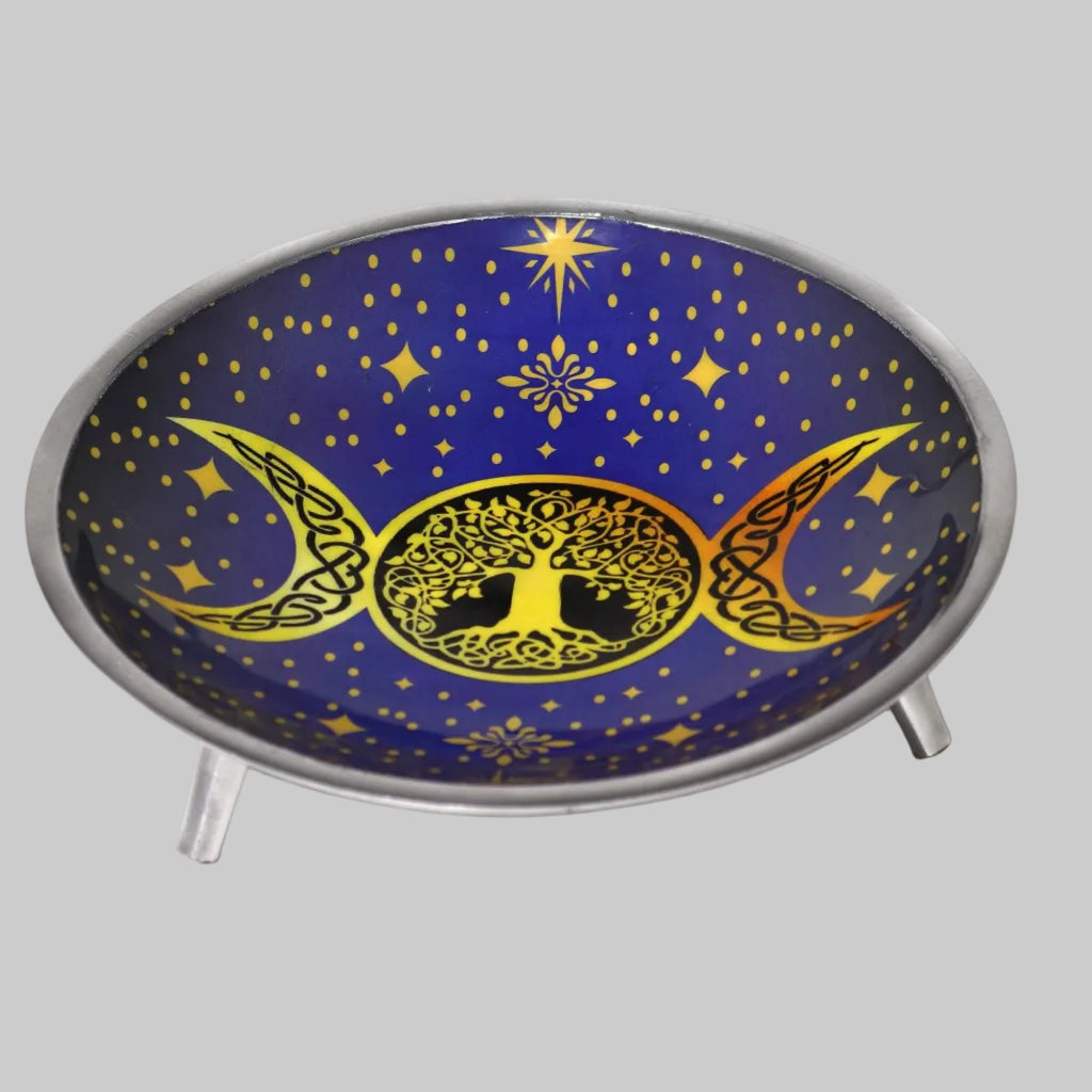 Decorative plate with tree of life design between two moons on a blue background with stars.