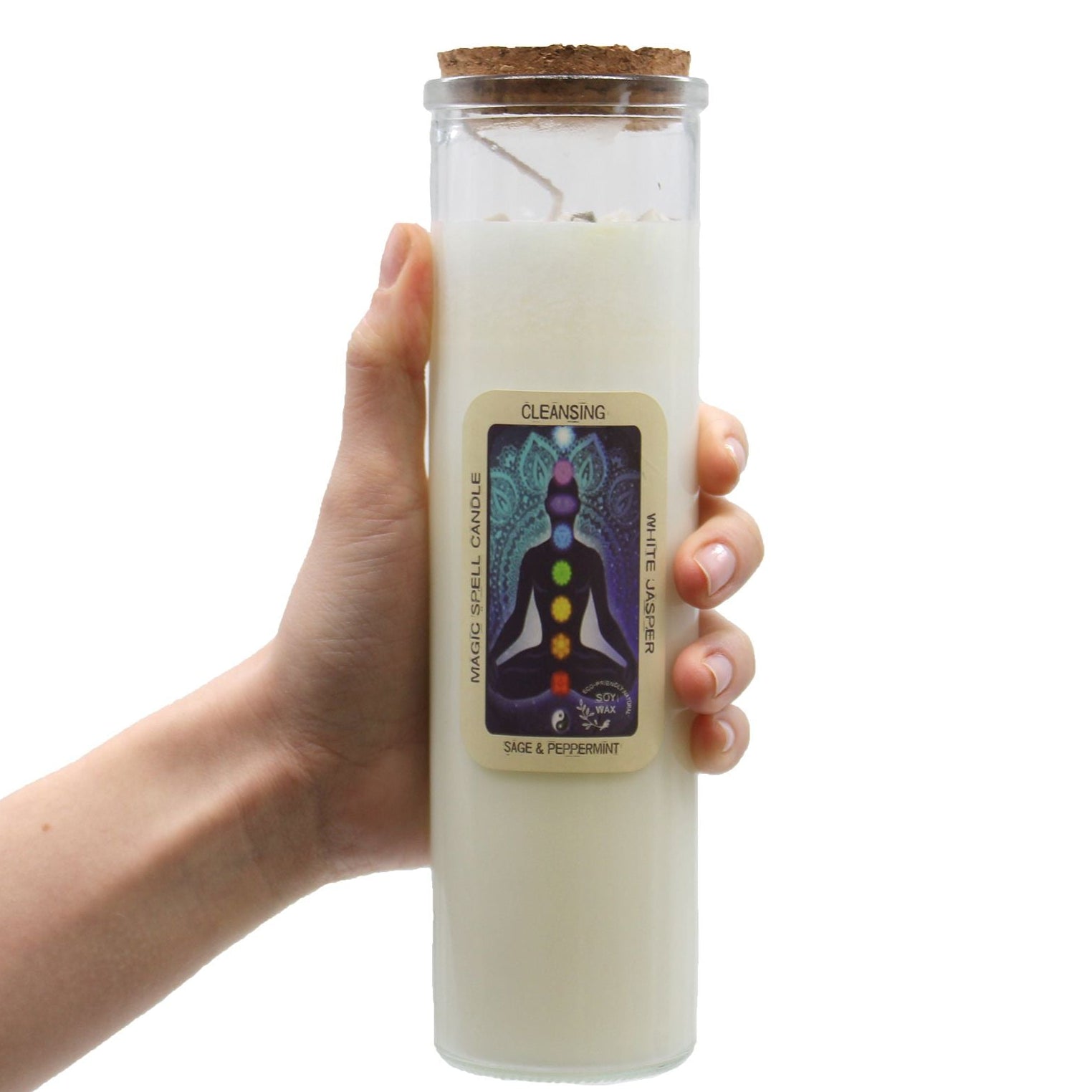 Hand holding a white candle in a glass jar with a label on a white background