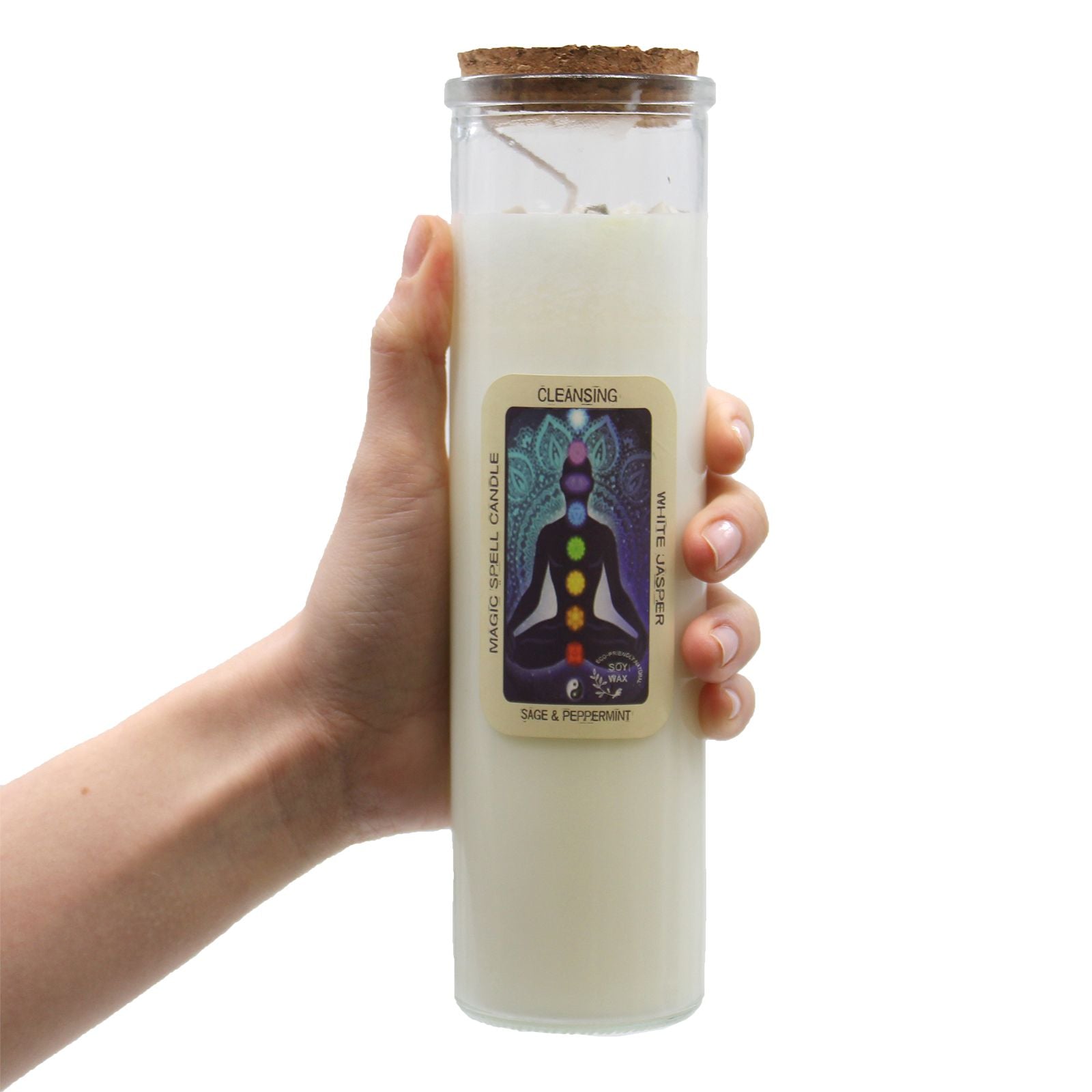 Hand holding a white candle in a glass jar with a label on a white background