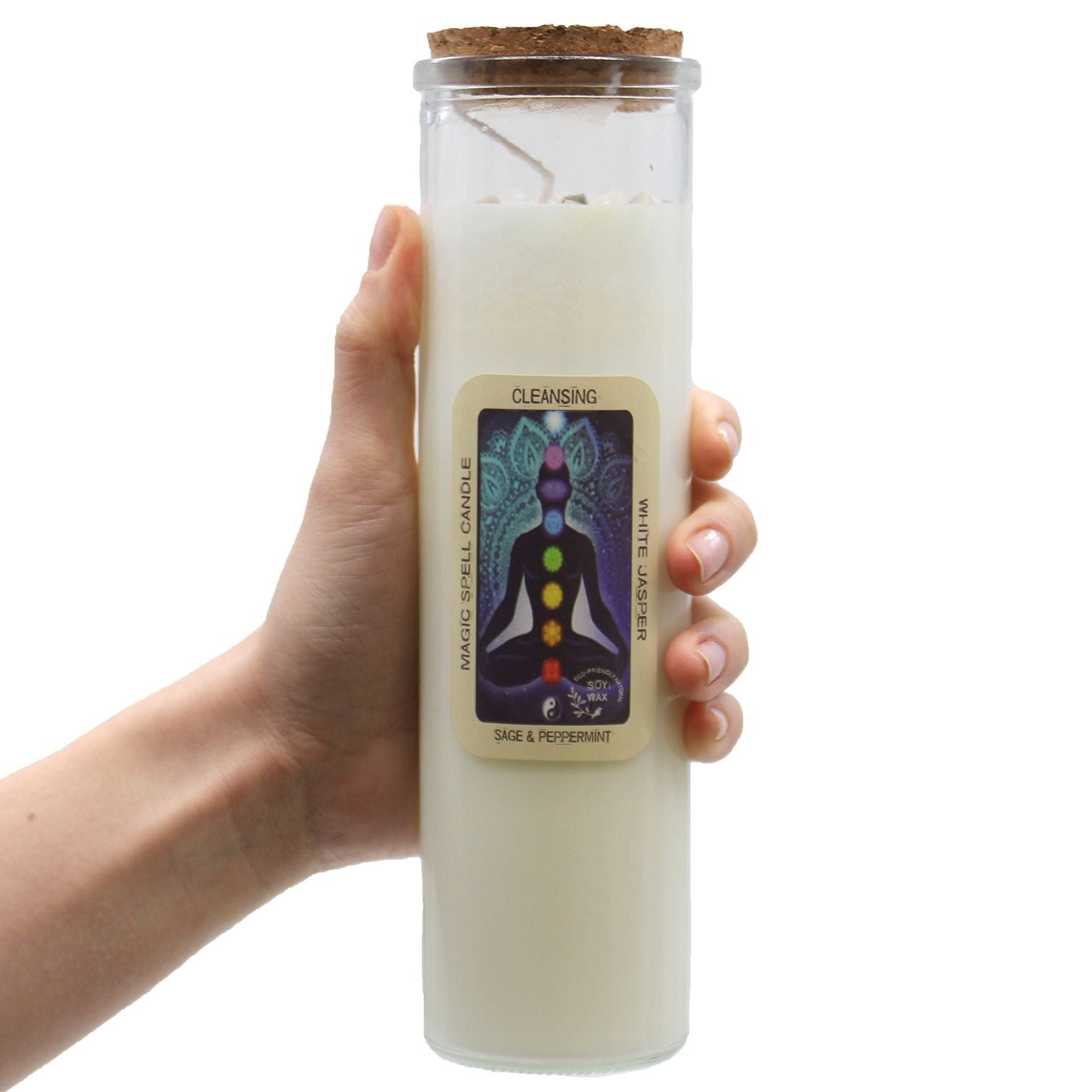 Hand holding a white candle in a glass jar with a label on a white background