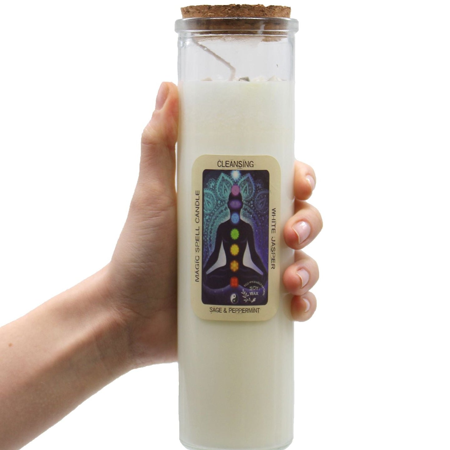 Hand holding a white candle in a glass jar with a label on a white background