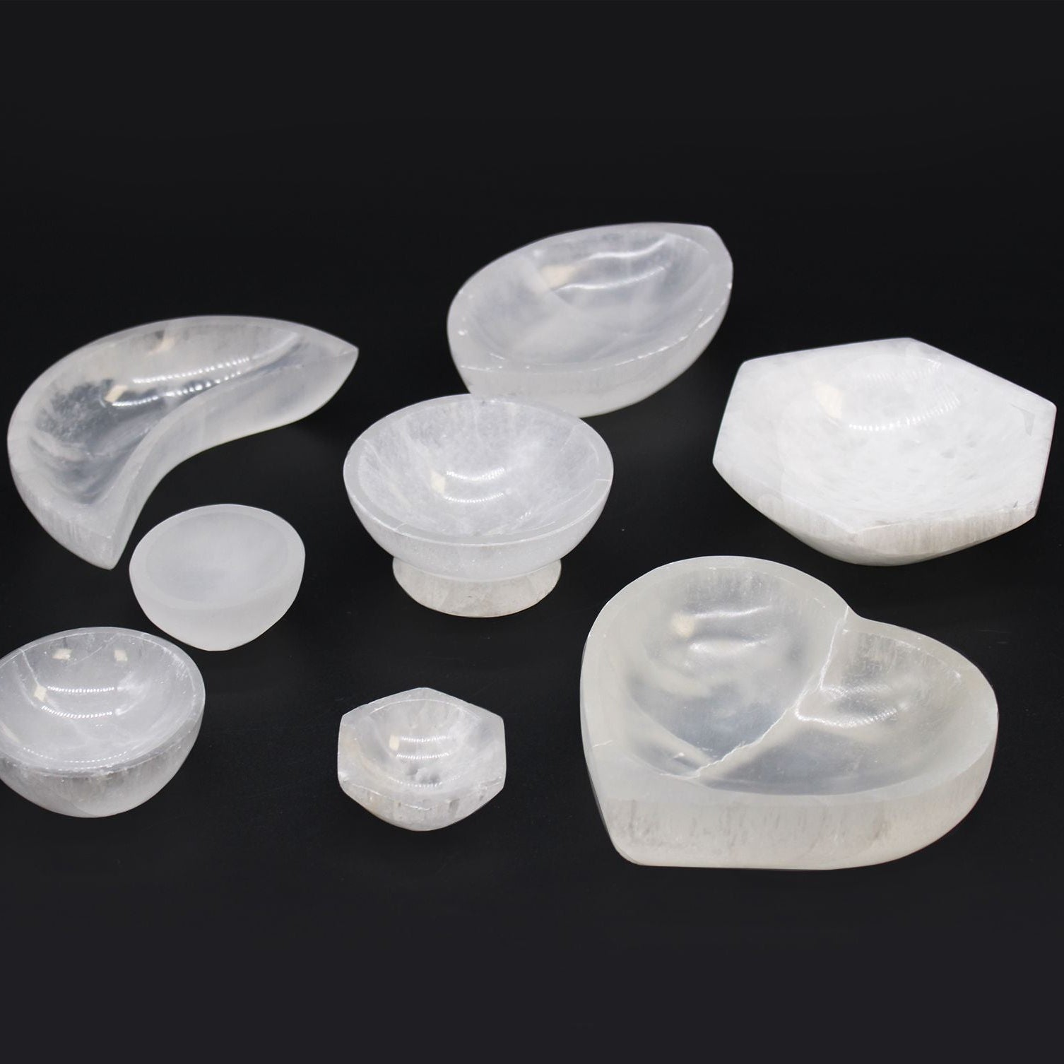 Set of various shaped white stones on a black background