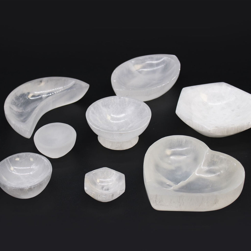 Set of various shaped white stones on a black background