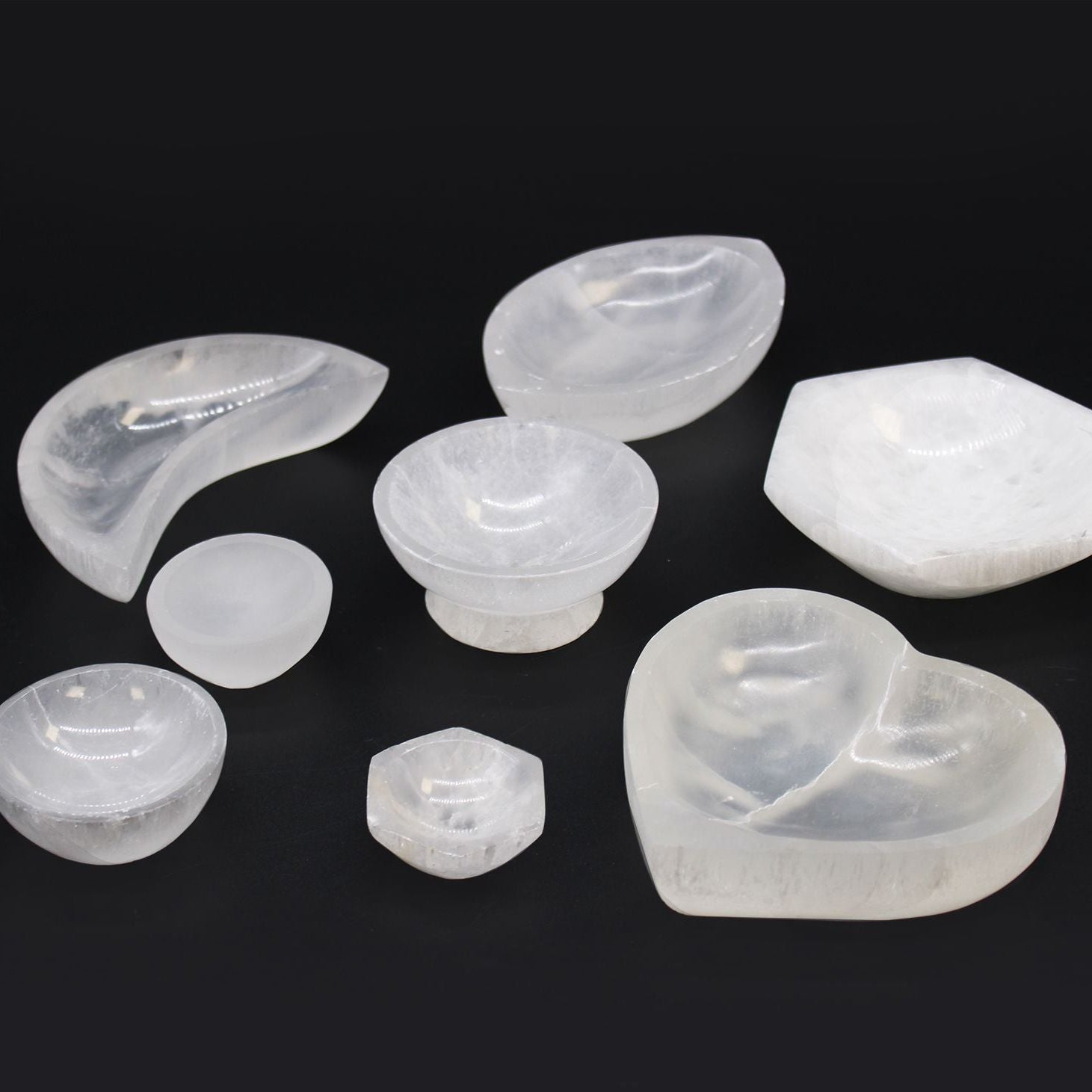 Set of various shaped white stones on a black background