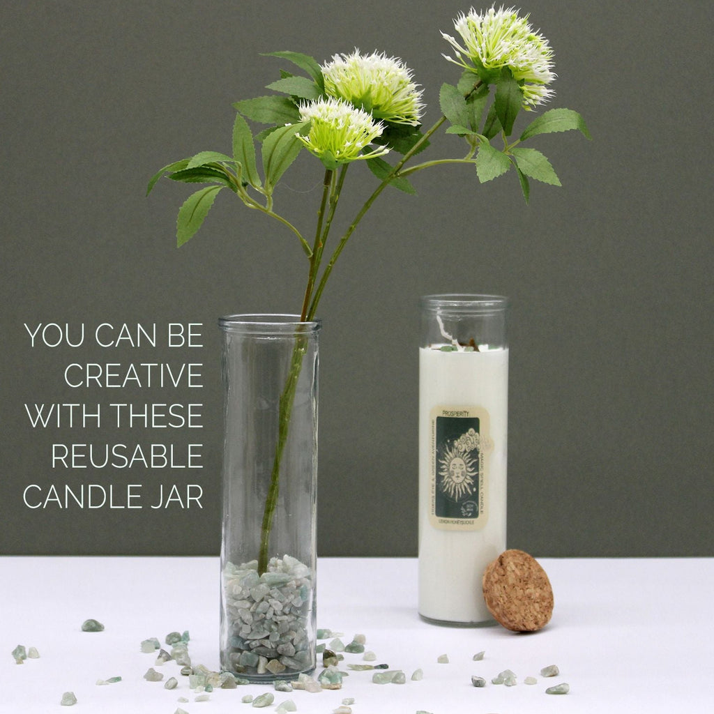 Reusable candle jar with a plant and decorative stones on a gray background