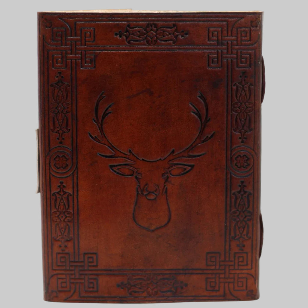 Brown leather notebook with deer head design and intricate patterns on a white background