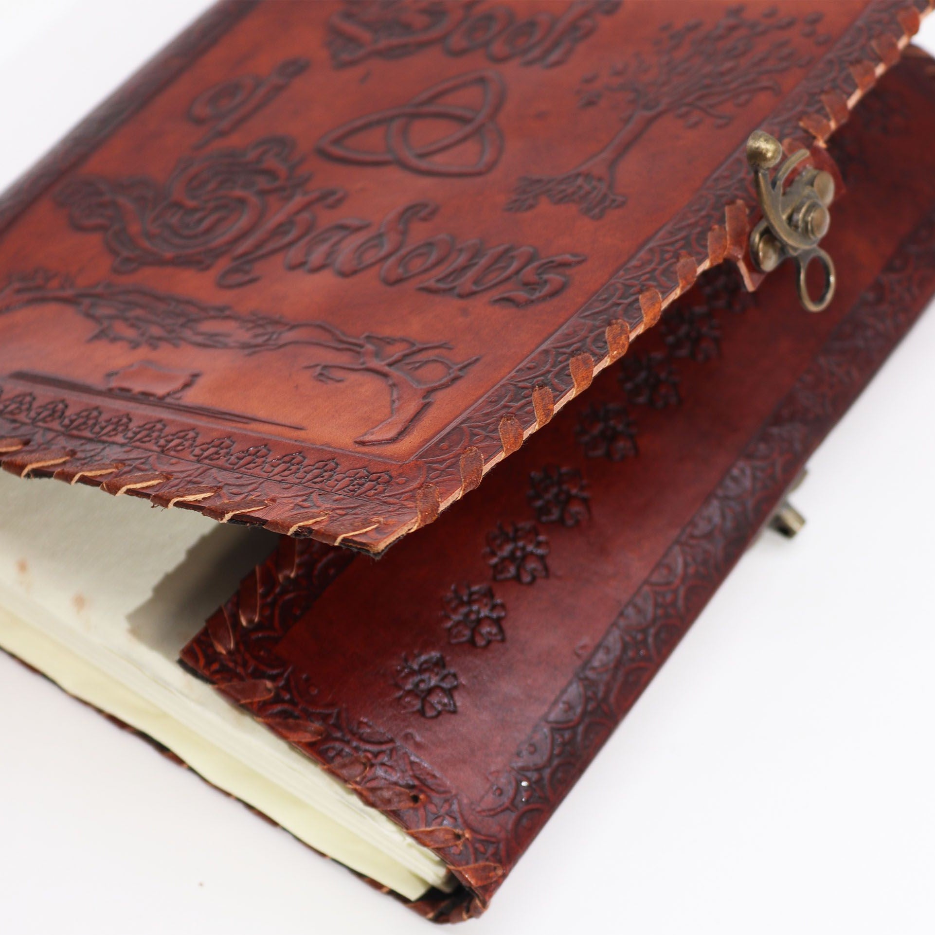 Brown leather notebook with embossed designs on a white background