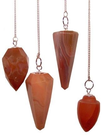 Set of four brown stone pendulums on silver chains against a white background
