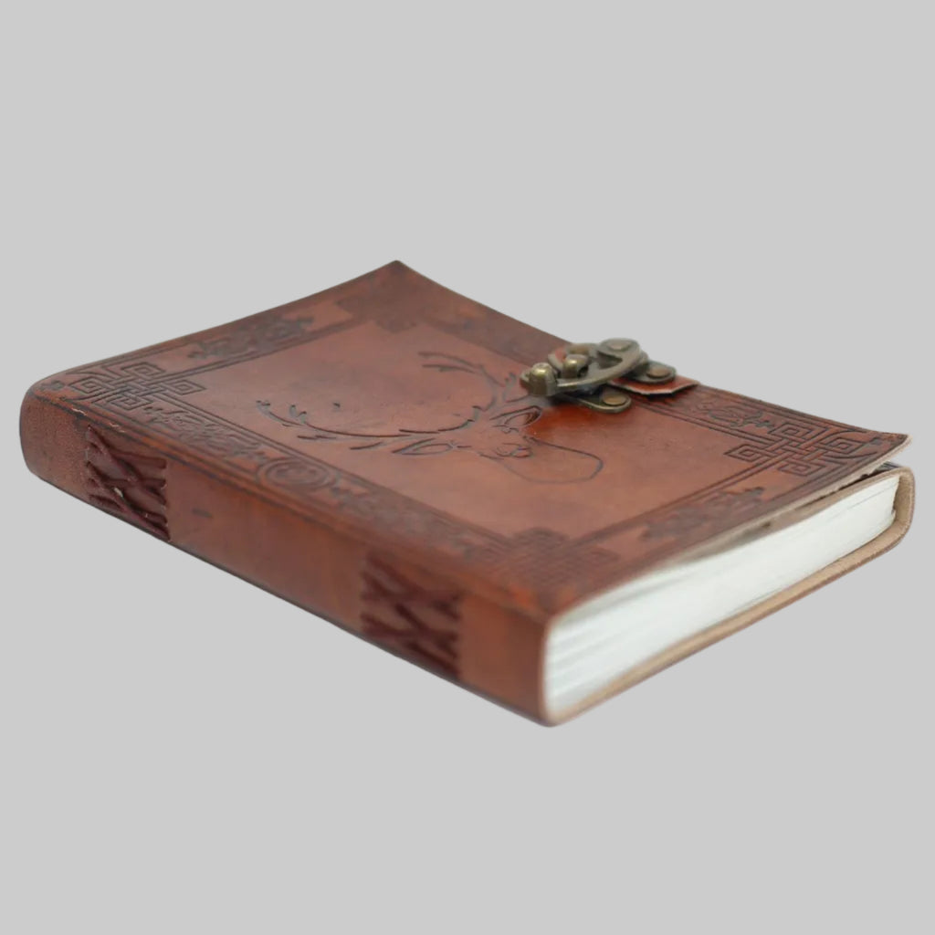 Brown leather journal with embossed design and clasp on a white background