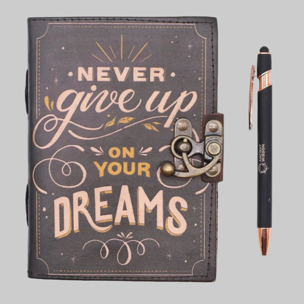 Decorative notebook with 'Never give up on your dreams' text and a pen on a white background