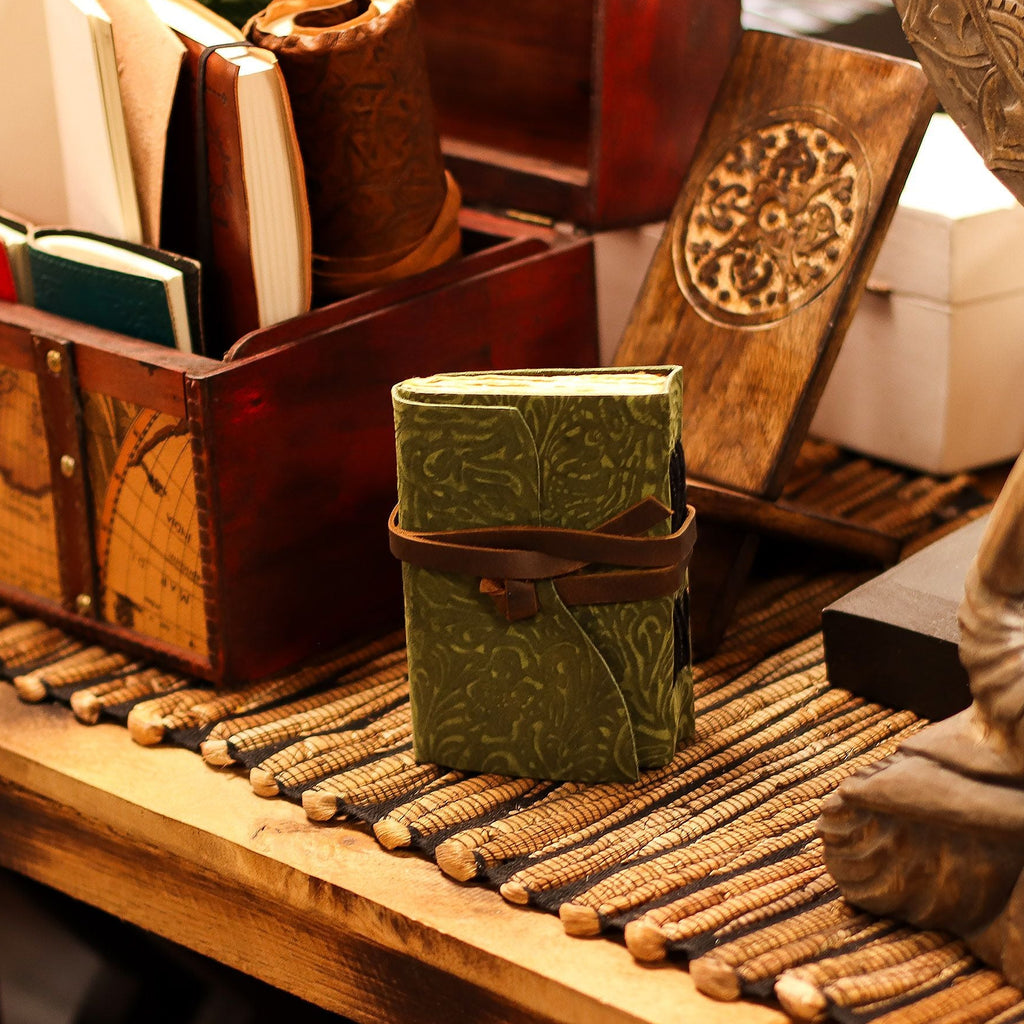 Green wrapped gift box on a wooden surface with decorative items
