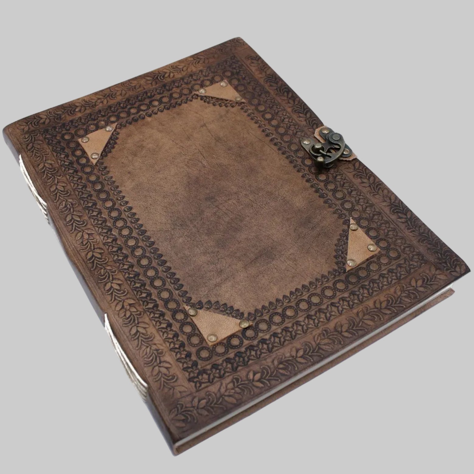 Decorative brown leather-bound book with embossed design on a white background