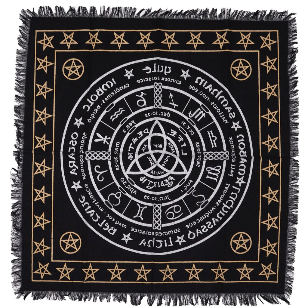 Black square cloth with white circular design and gold stars and symbols