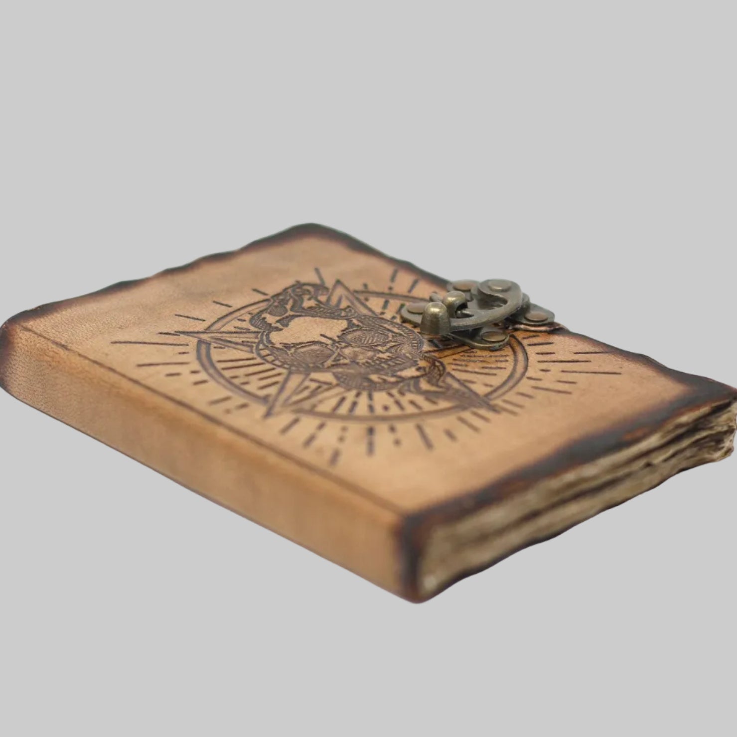 Wooden book with compass design and metal clasp on a white background