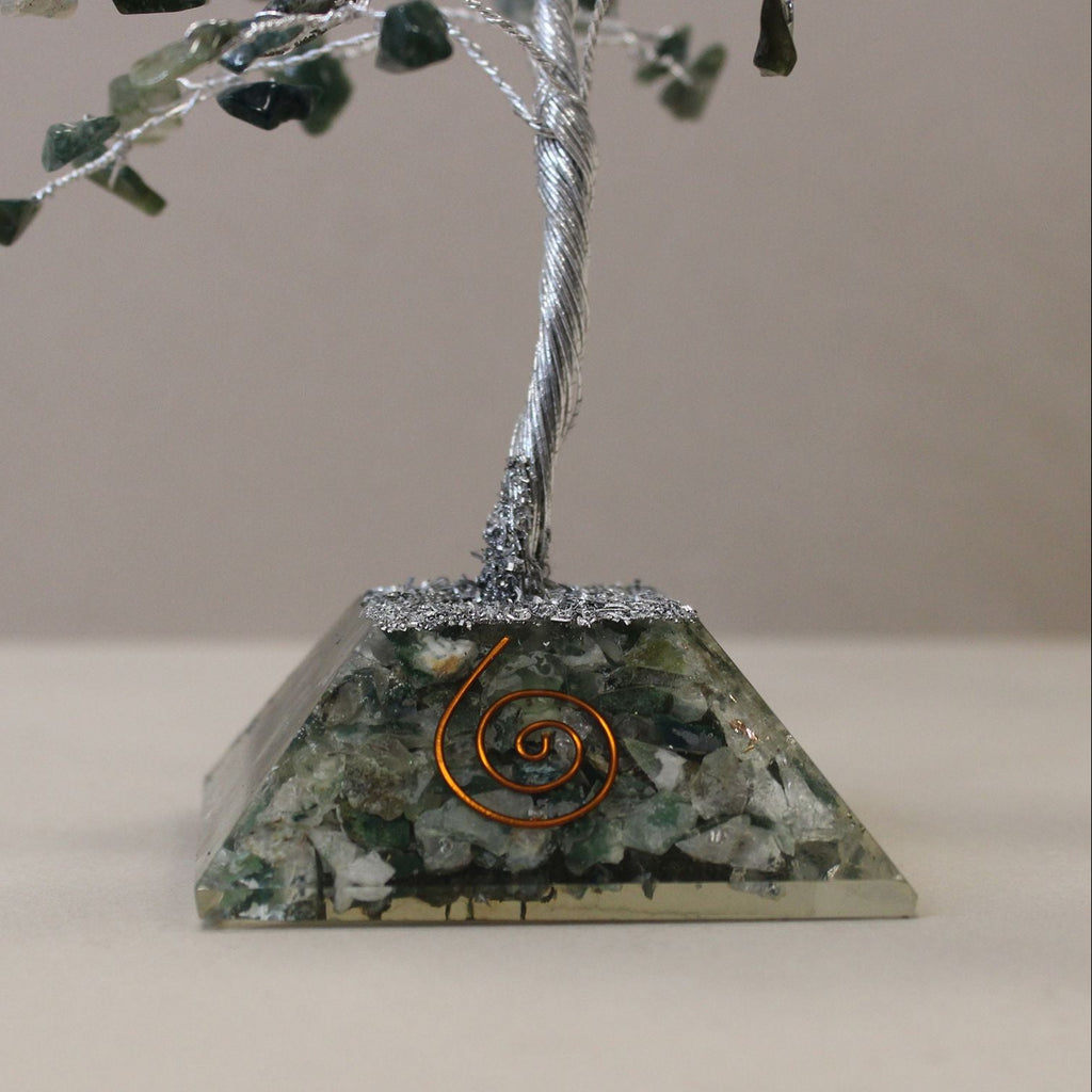 Decorative piece with a tree on a pyramid base featuring green stones and a copper coil.