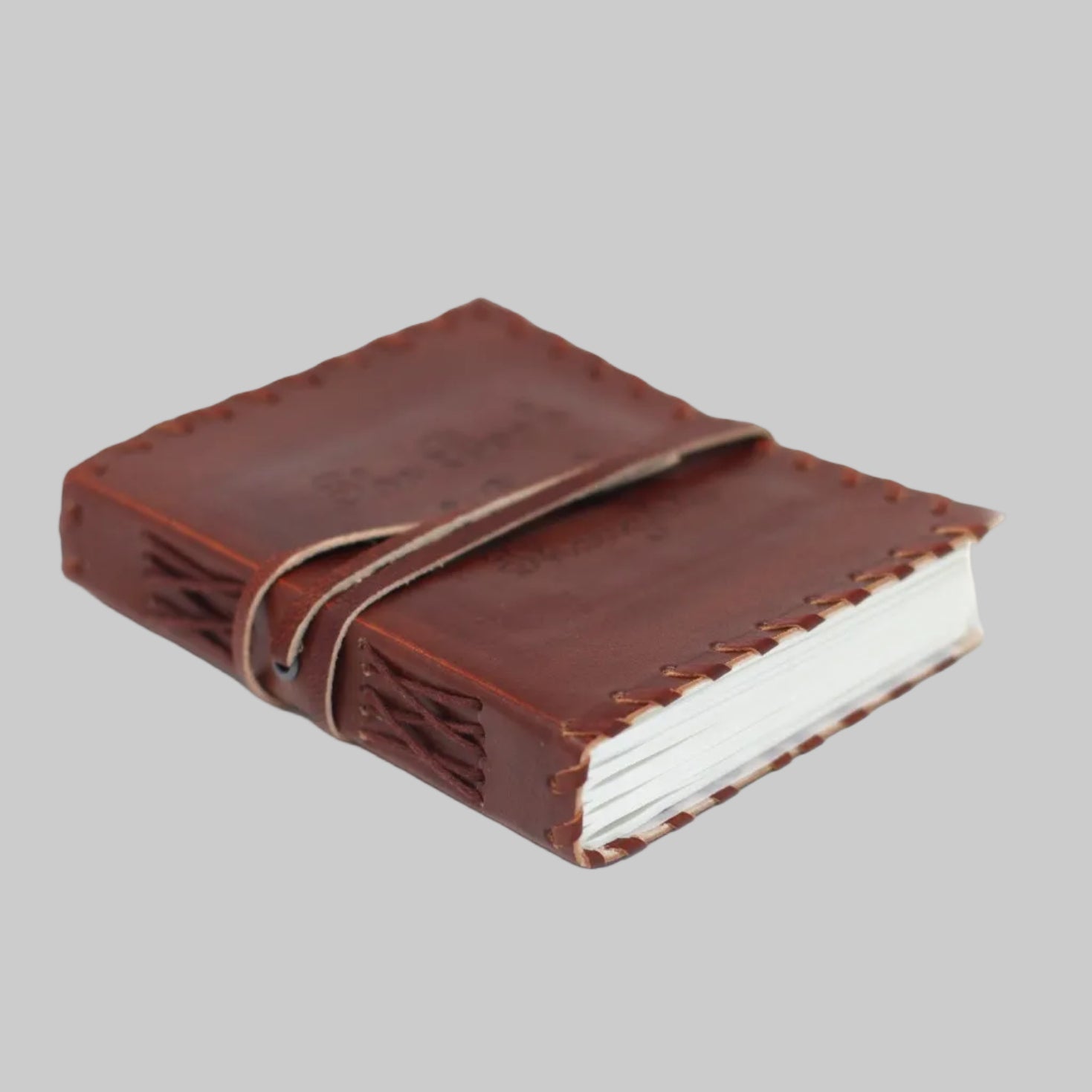 Brown leather-bound notebook with white pages on a white background