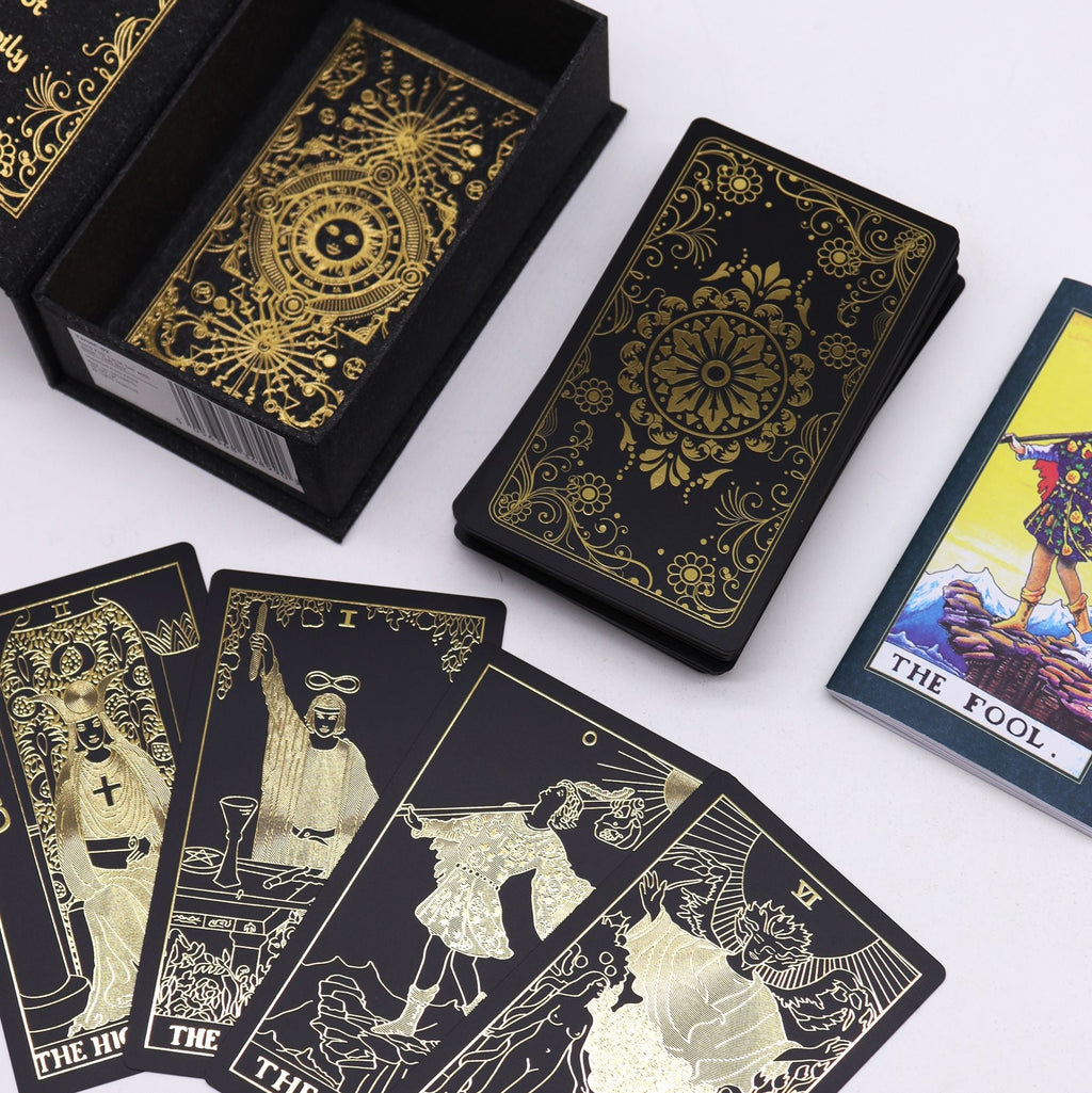 Black tarot cards with gold designs and a few cards displayed on a white background.