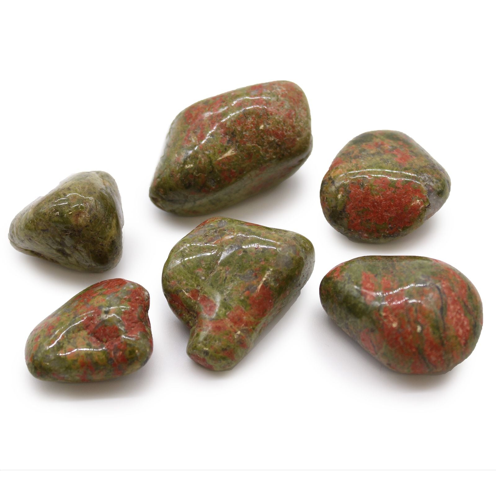 Seven green and red stones on a white background