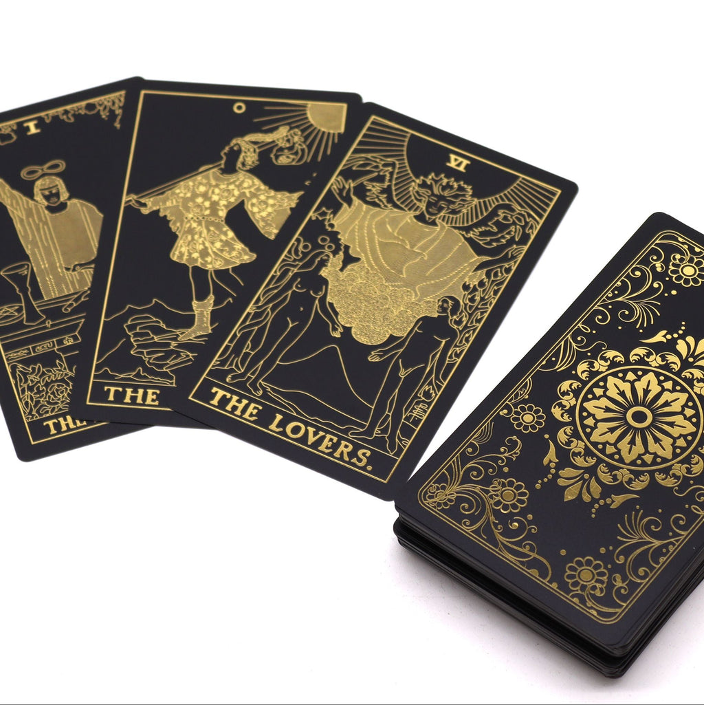 Black tarot cards with gold illustrations on a white background