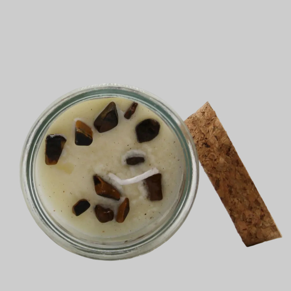 Jar of dessert with chocolate chunks and a cinnamon stick on a white background