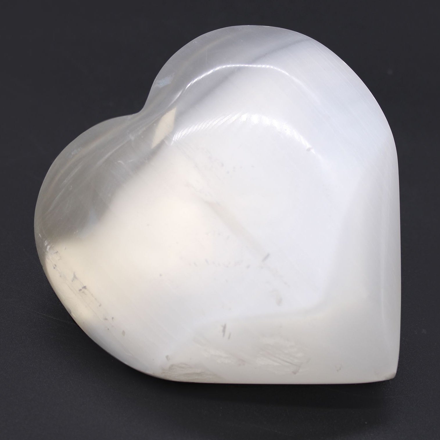 Heart-shaped white stone on a black background