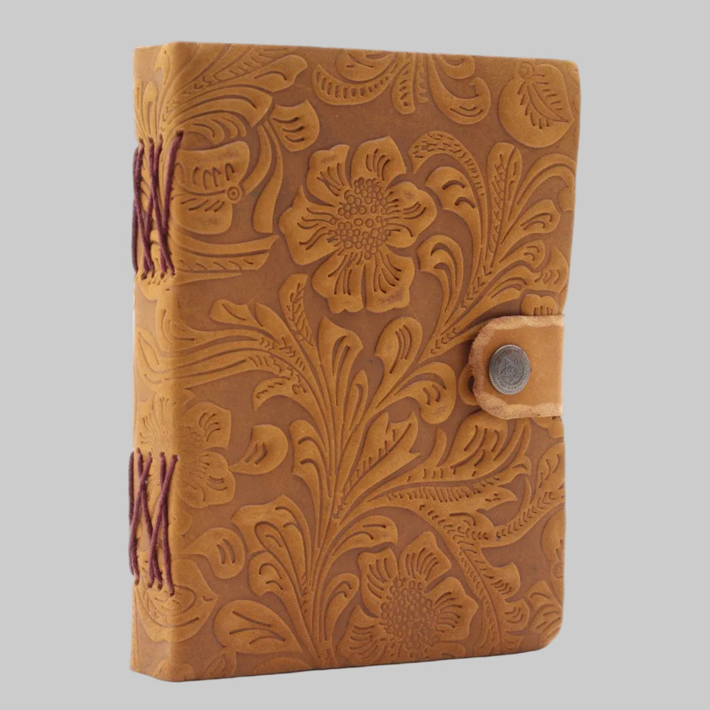 Brown leather notebook with floral embossing on a white background