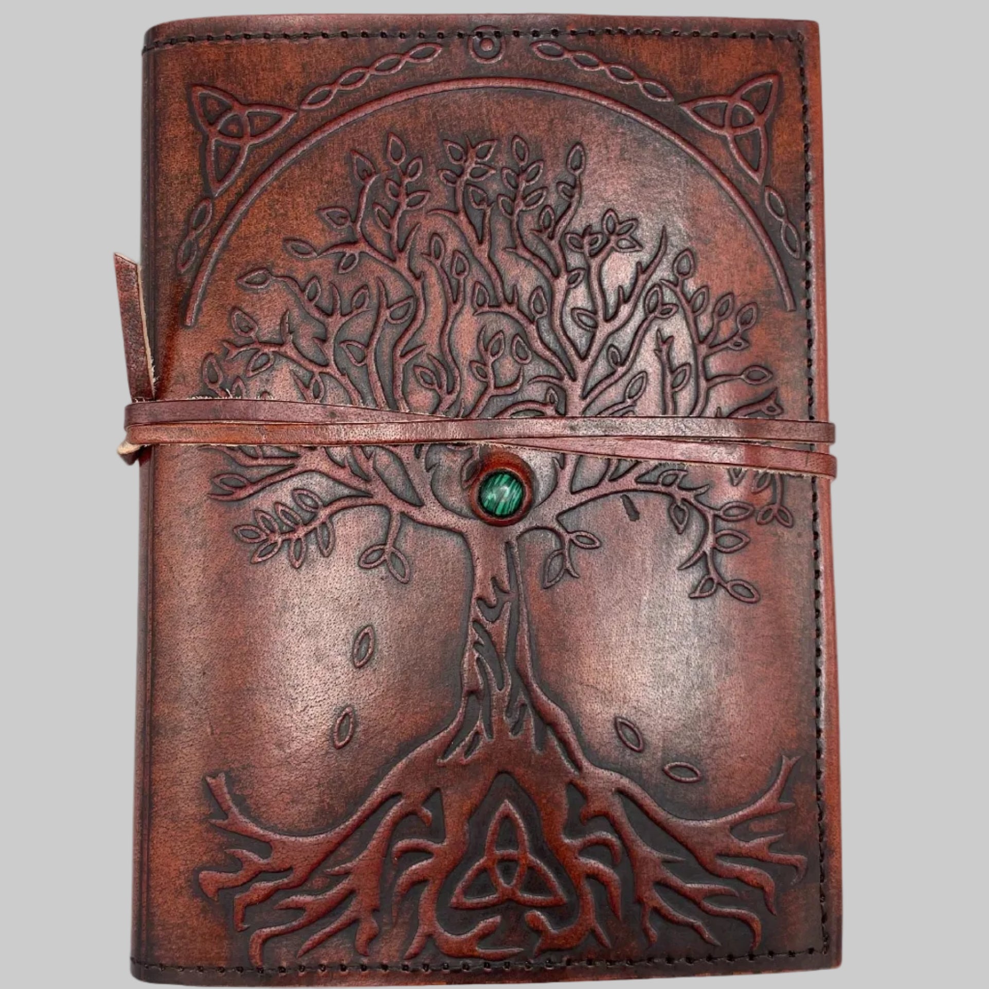 Brown leather journal with tree of life design on a white background