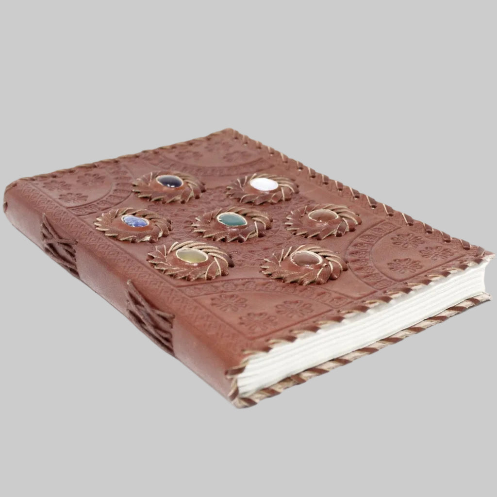 Brown leather notebook with embossed designs on a white background