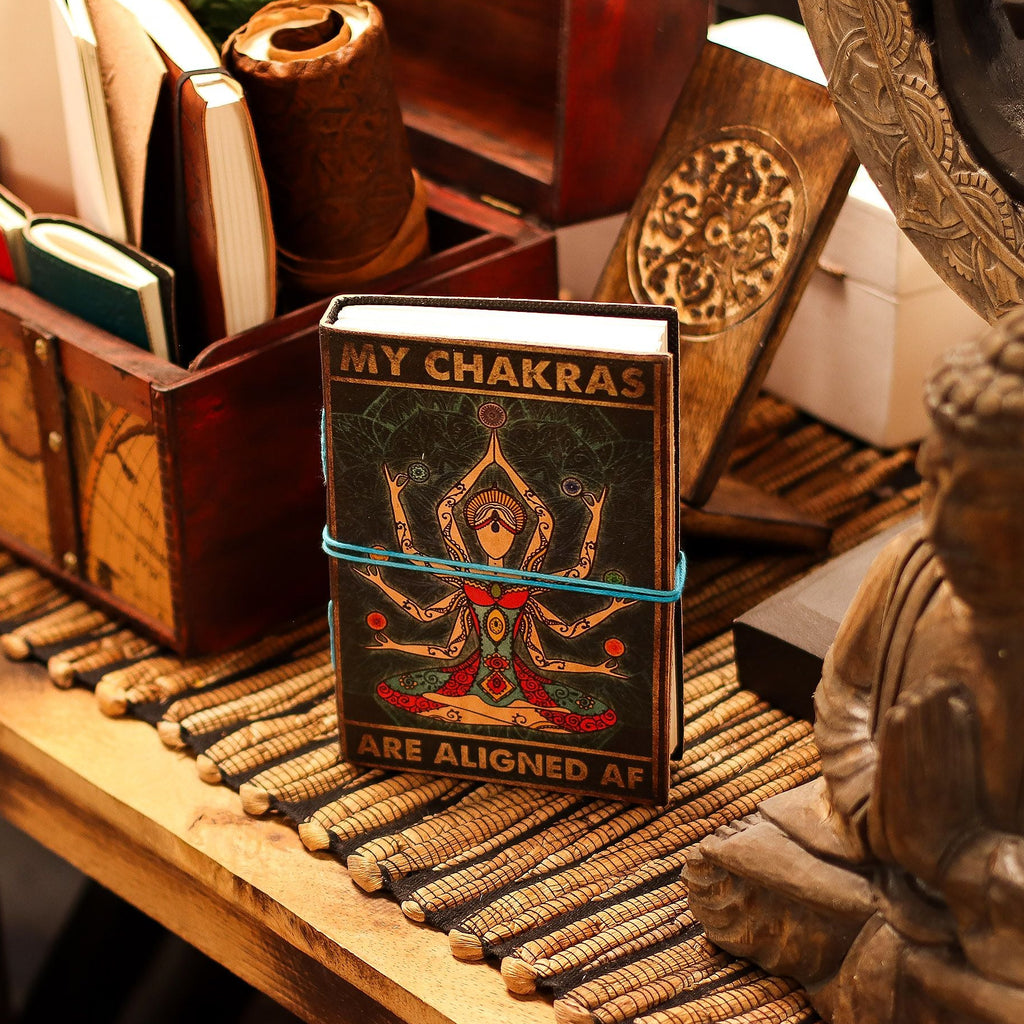 Small book titled 'My Chakras Are Aligned AF' on a wooden surface with decorative items.