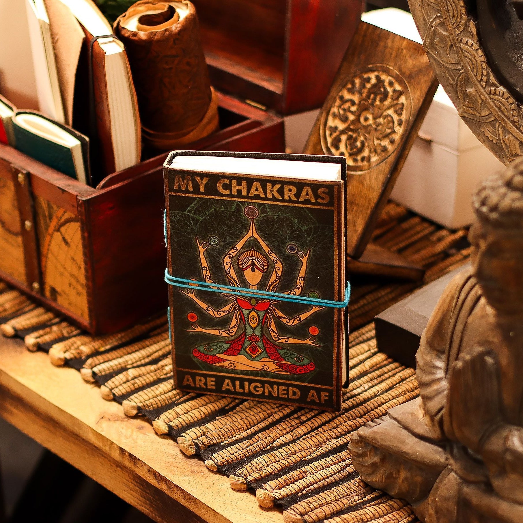Small book titled 'My Chakras Are Aligned AF' on a wooden surface with decorative items.