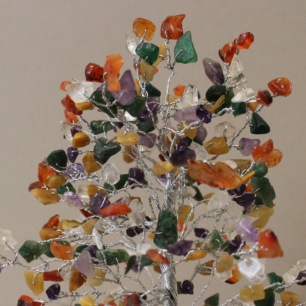 Decorative tree made of multicolored stones on a plain background