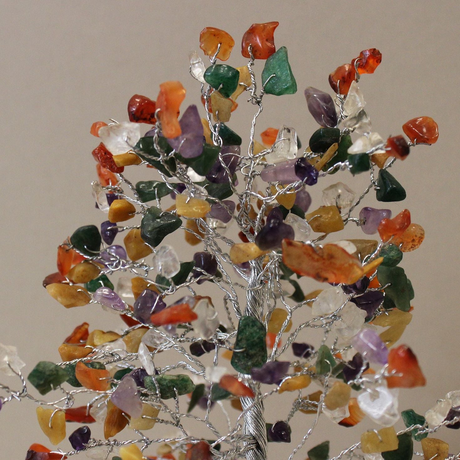Decorative tree made of multicolored stones on a plain background