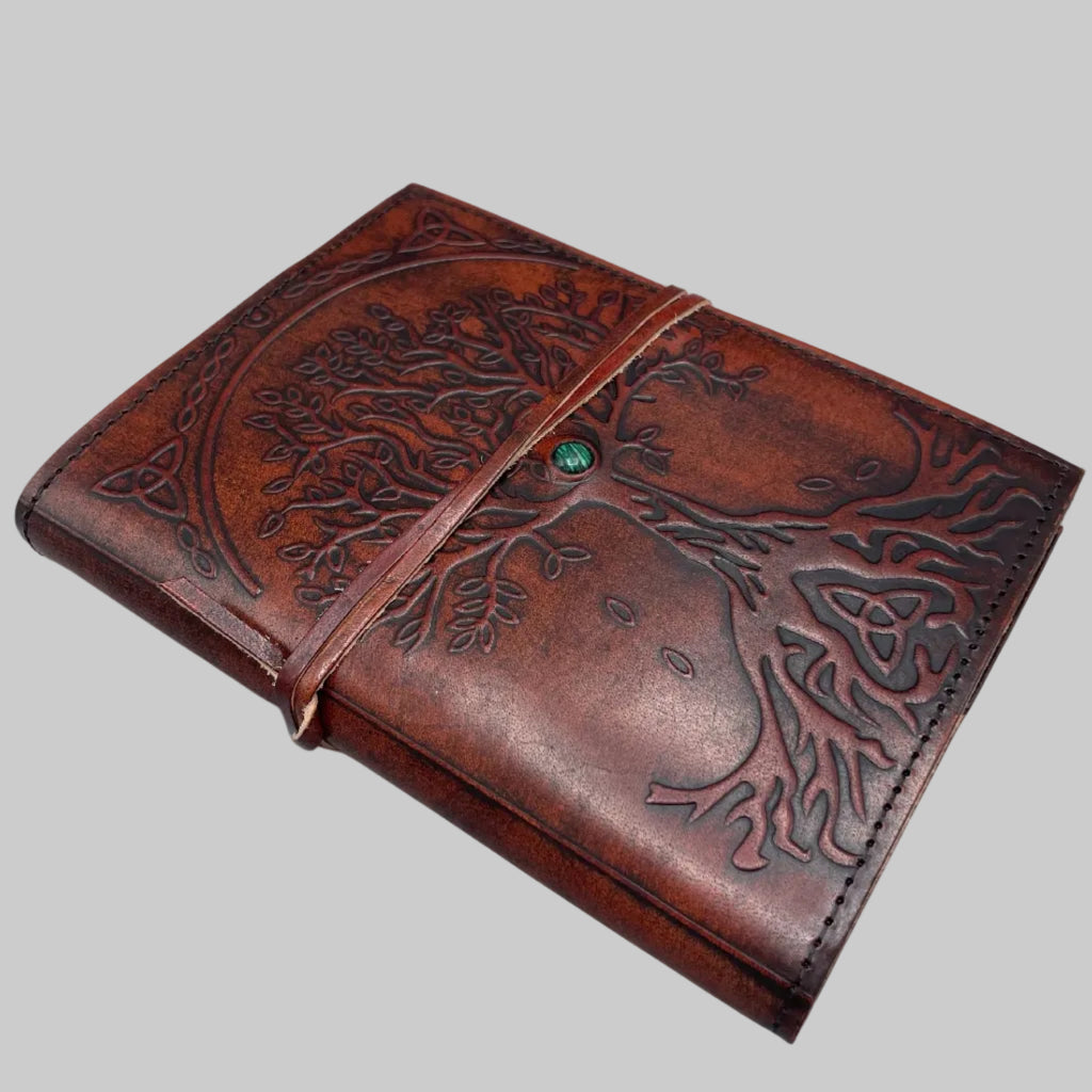 Brown leather journal with tree of life design on a white background