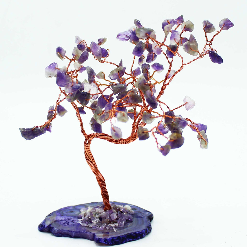 Decorative tree made of purple and white stones on a blue base with a white background