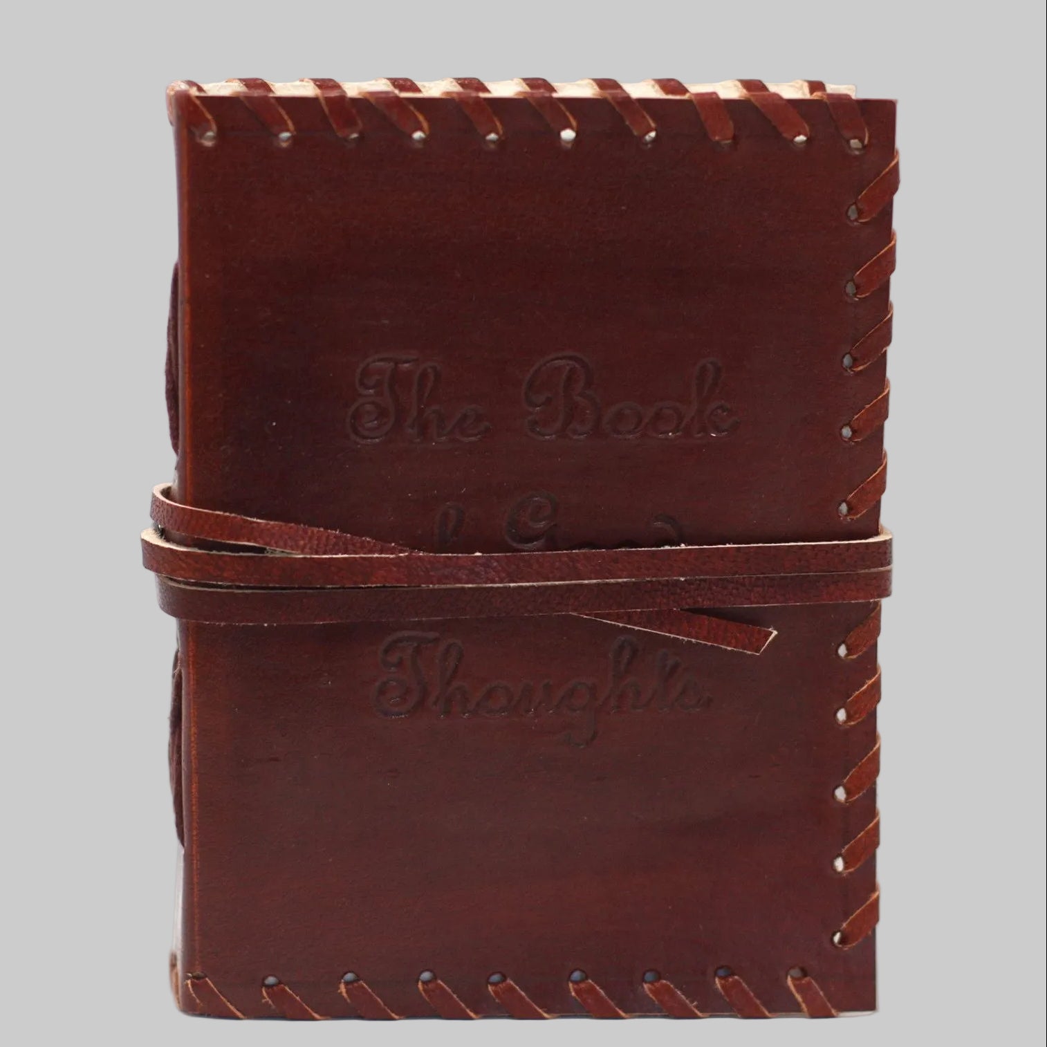 Brown leather notebook with visible stitching on a white background