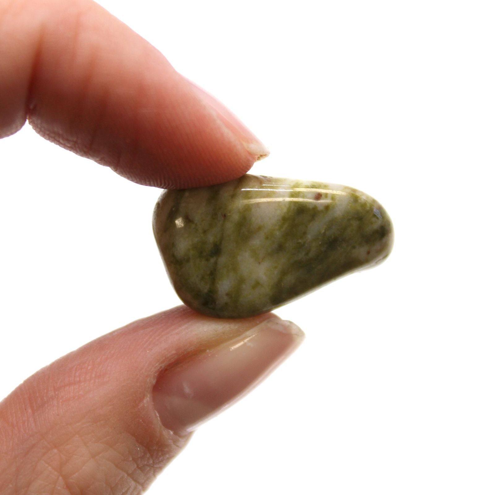 Hand holding a small greenish stone against a white background