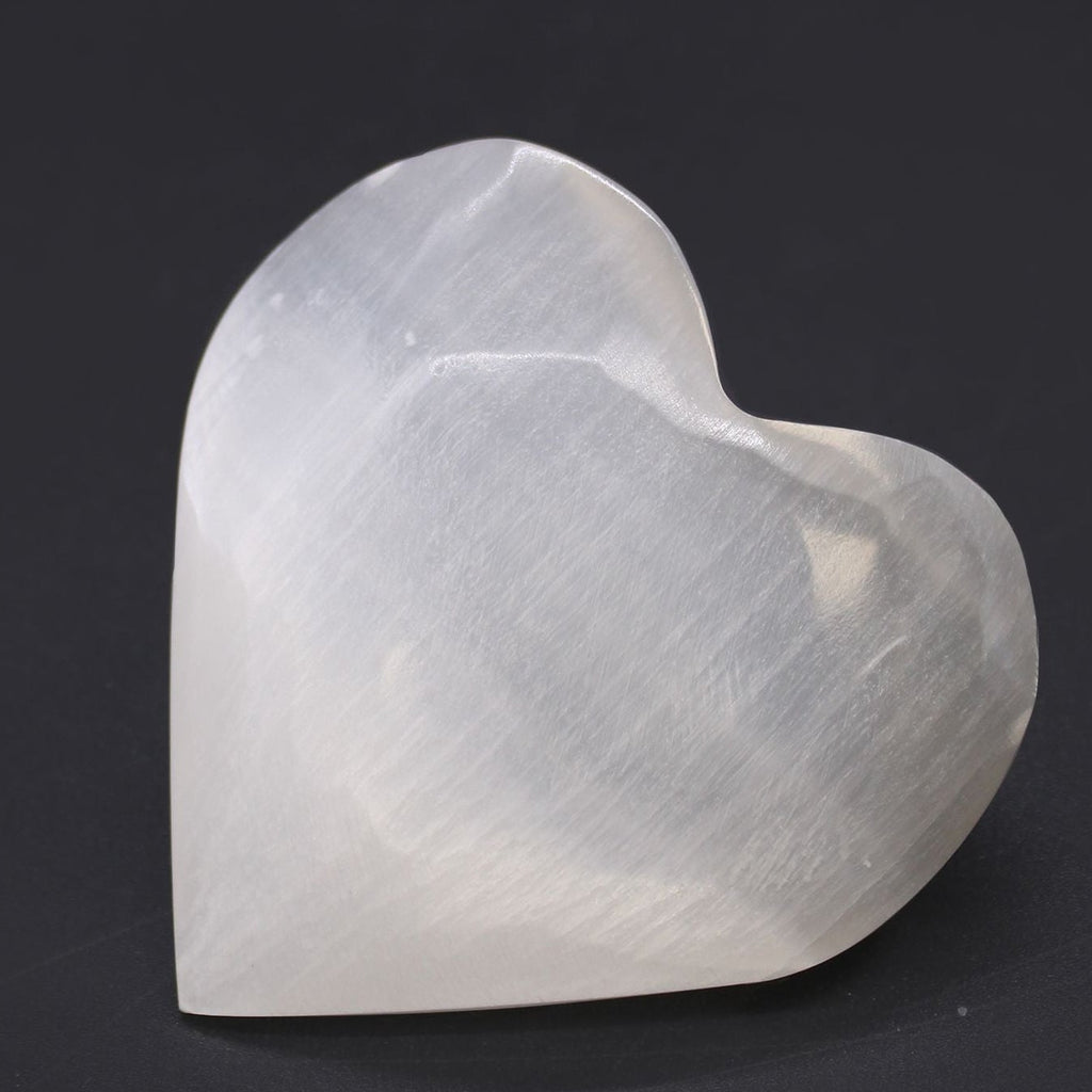 Heart-shaped white stone on a black background