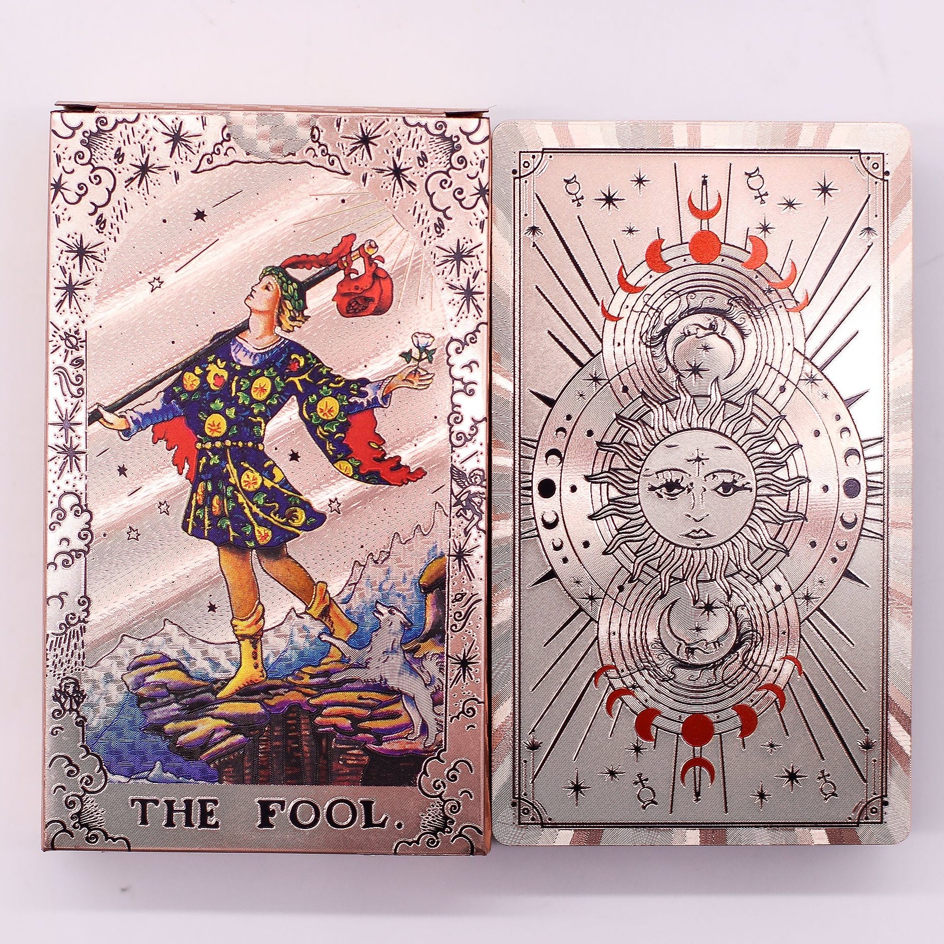 Two tarot cards, 'The Fool' on the left and a decorative card with celestial design on the right, on a white background.