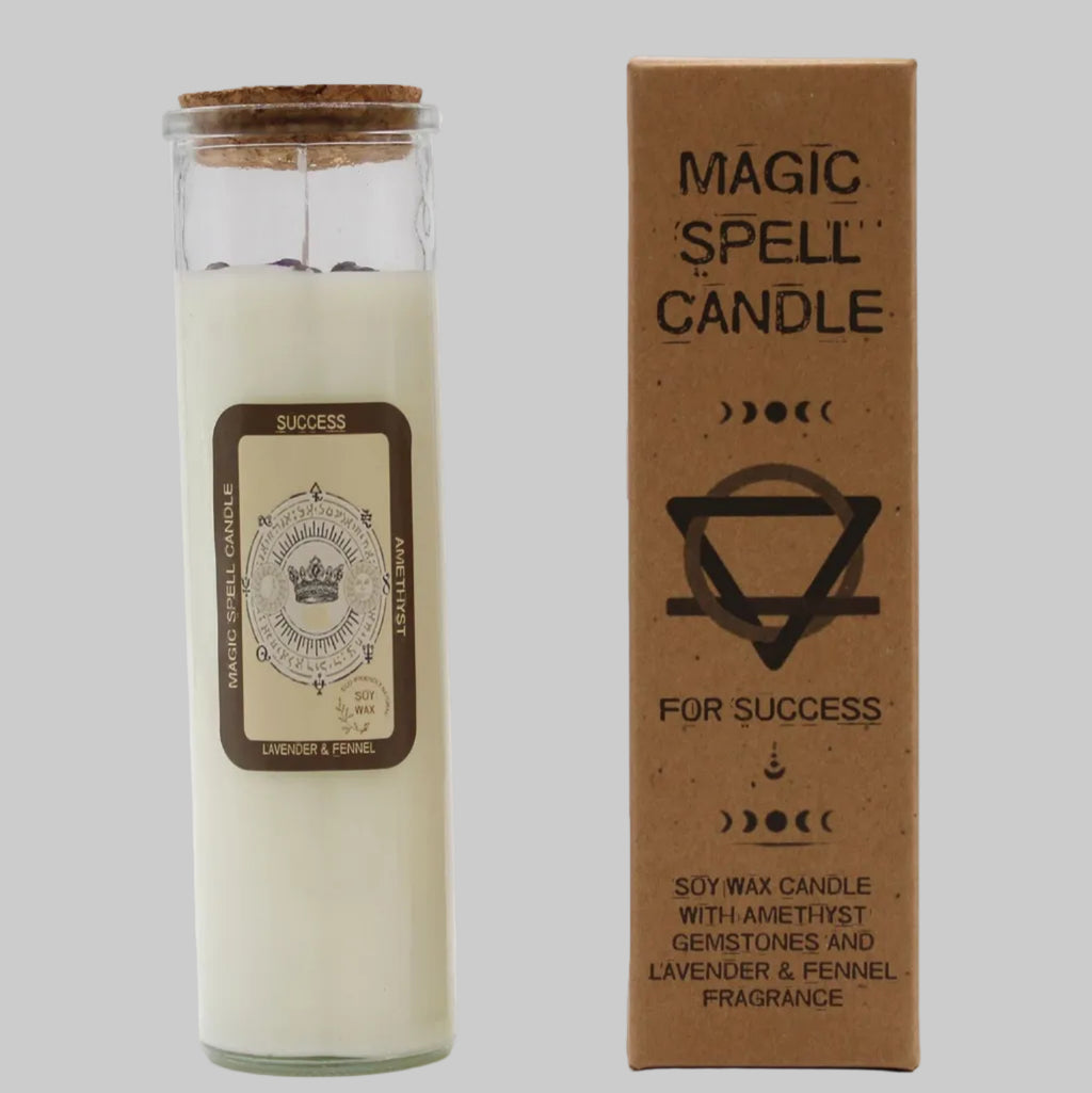 Candle in a glass jar with a cork lid next to its packaging box on a white background